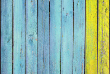 blue and yellow old wooden fence. wood palisade background. planks texture