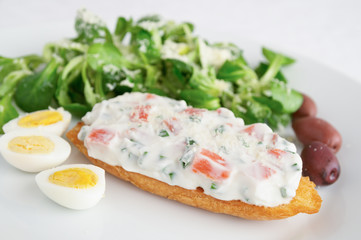 breakfast set with cream cheese and red salmon sandwich, eggs, corn salad and olives