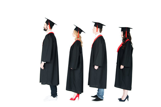 Full length side view of students in academic caps and graduation gowns standing in a row