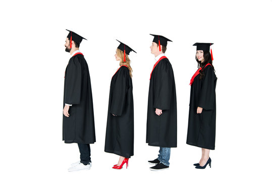 Full length side view of students in academic caps and graduation gowns standing in a row