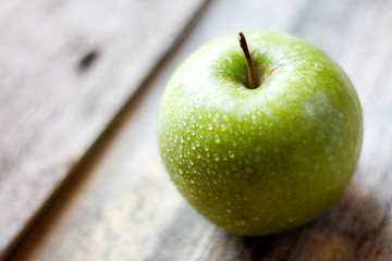 Green apple close up on a wooden background 