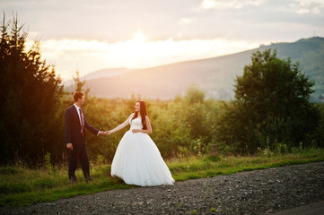 Lovely wedding couple against sunset at Carpathian mountains.