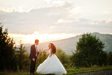 Lovely wedding couple against sunset at Carpathian mountains.