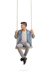Teenager sitting on a swing and looking to the left