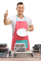 Young man showing clean plate and making thumb up gesture