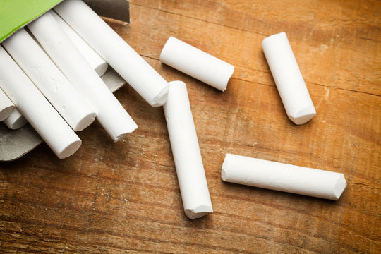 Tizas blancas sobre una mesa de madera r&uacute;stica. Vista superior