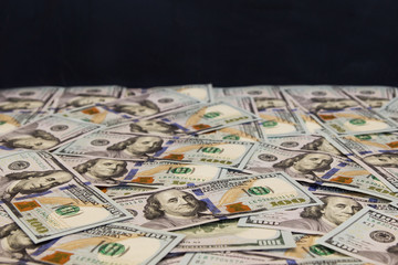 A lot of dollar bills On a black background

