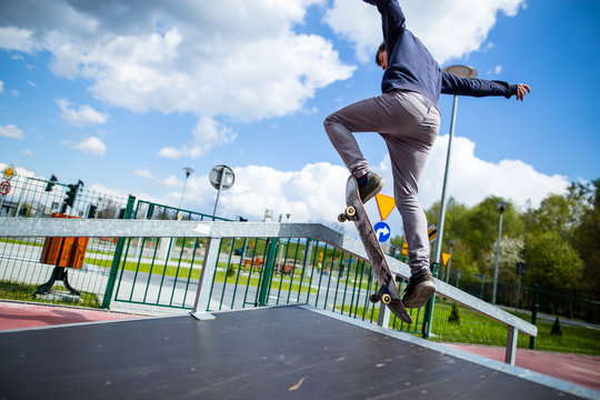 Skater doing ollie trick over funbox in skatepark