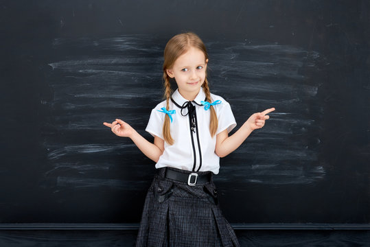 Little girl against blackboard. School concept