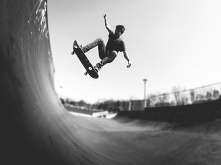 Skateboarder doing ollie on ramp -  black and white - obrazy, fototapety, plakaty