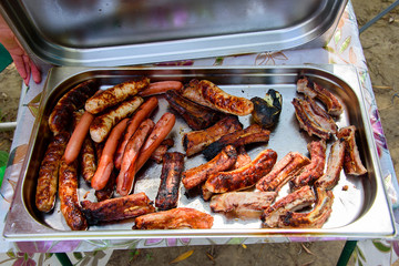 Fried bbq meat and sausages in iron pan