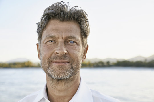 Portrait of smiling mature man with stubble in front of the sea