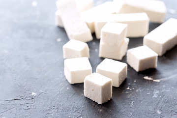Marshmallow sticks and cubes lying on background Copy space on the left
