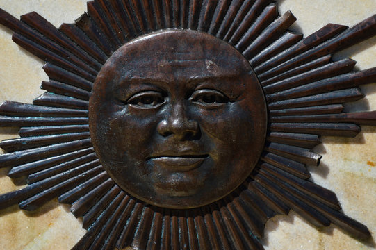 board in metal with figure of the sun