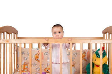 Sad Infant child baby girl toddler in wooden bed on white background