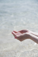 Fototapeta na wymiar a hand which is trying to hold a water from the sea