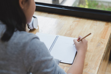asian girl female teenager lying on floor and writing word 