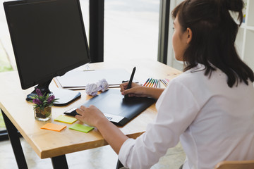 freelance graphic designer drawing on digital tablet. woman working with color swatch catalog samples for selection - Creativity Editor Ideas Concept