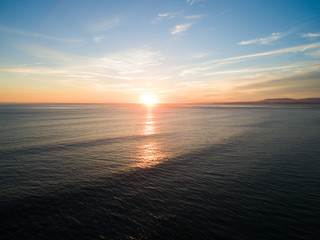 Aerial video in motion of sunset in the Atlantic Ocean in Costa da Caparica, Lisbon, Portugal