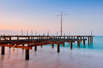 Naklejka premium Old pier in the sea at dawn
