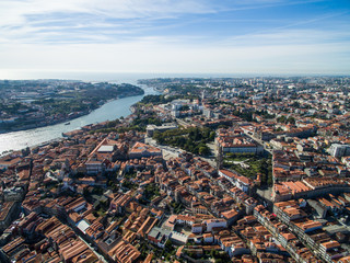 Fototapeta na wymiar Panoramic view of the old city of Porto. One flew over the roofs of the houses, a river and a bridge.