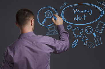 Business, Technology, Internet and network concept. A young businessman writes on the blackboard the word: Privacy alert