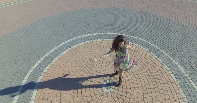 Ragazza gira allegramente al centro di una piazza di un paese calabrese