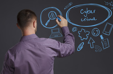 Business, Technology, Internet and network concept. A young businessman writes on the blackboard the word: Cyber crime