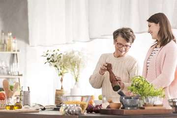 Selbstklebende Fototapete Kochen Enkelin und Großmutter kochen