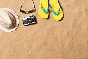 Fototapeta na wymiar Pair of flip flop sandals, sunglasses, hat and camera.