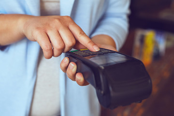 Close up of female hands entering PIN number, toned