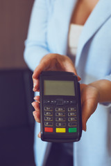 Female hands holding a payment terminal, toned