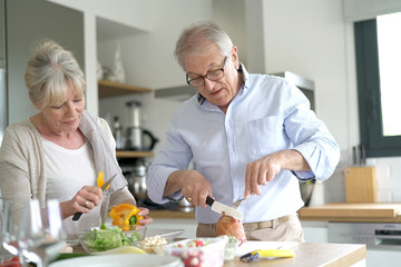 Fototapeta na wymiar Senior couple cooking together in home kitchen