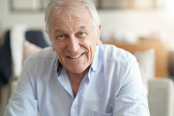 Fototapeta na wymiar Portrait of senior man standing in living-room