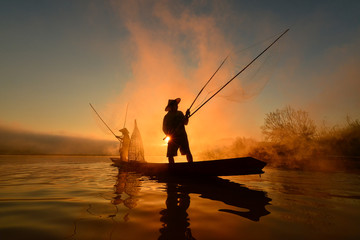 The silluate fisherman boat in river  on during sunrise,Thailand