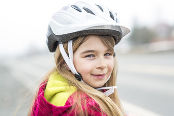 Little girl riding a bike in a city