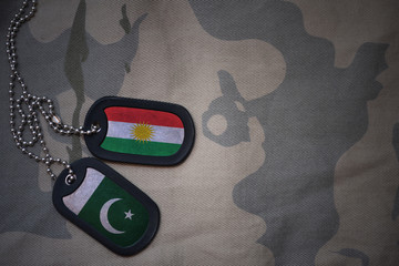 army blank, dog tag with flag of kurdistan and pakistan on the khaki texture background. military...