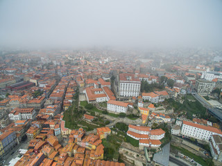 Fototapeta na wymiar Flight over the narrow streets of the old town of Porto at the fog