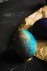 Rustic colored easter eggs on the dark stone background. Shallow depth of field.