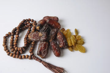 Dates,raisin and rosary isolated on white.