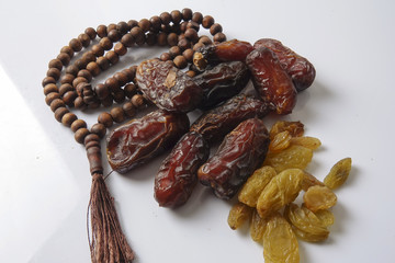 Dates,raisin and rosary isolated on white.