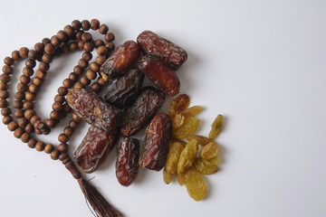Dates,raisin and rosary isolated on white.