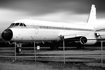 Fototapeta na wymiar Flugzeug auf Flugzeugfriedhof / Die Seitenansicht eines alten stillgelegten Passagierflugzeuges auf einem Flugzeugfriedhof.