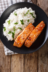 Glazed salmon fillet with rice garnish close-up. Vertical top view