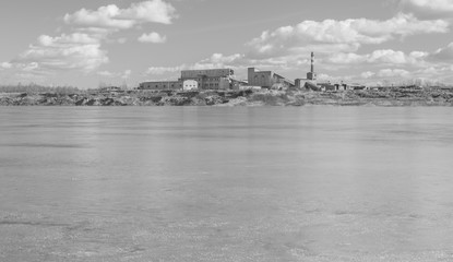 black and white, on the banks of clay pit is an old plant.