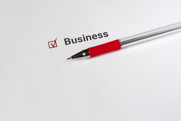 Questionnaire. Red pen and the inscription Business with check mark on the white paper