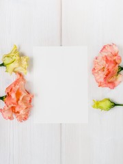 Pink flowers and white sheet on wooden background.