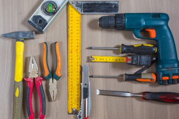 Different tools on a wooden background. Hammer, drill, pliers. Screwdriver, ruler, cutting pliers