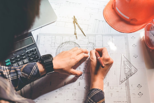 Architect or engineer working in office on blueprint. Architects workplace , blueprints, ruler, helmet and divider. Construction concept. Engineering tools