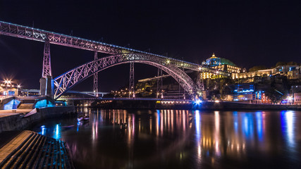 Fototapeta na wymiar Porto by night. View of the waterfront Douro River and Luis I Bridge. Portugal